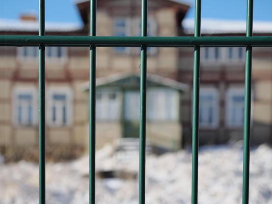 Wohngebäude mit Fenstern hinter einem Zaun. Digitale Farbaufnahme für Mastoart.