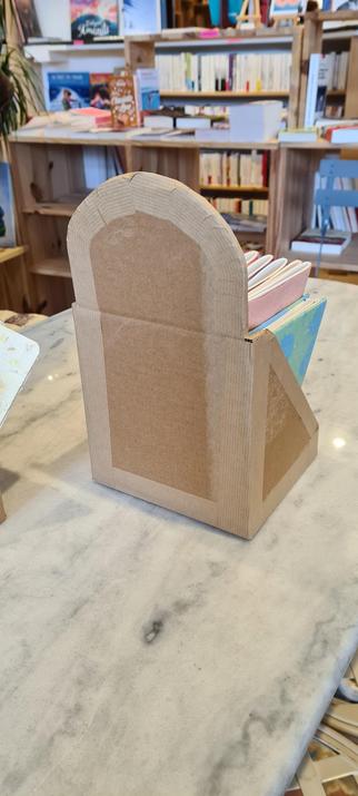 Dos d'un présentoir où l'on peut voir les bandes de kraft enduite de colle qui construise le présentoir.