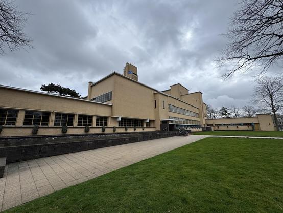 Hilversum city hall by the architect Dudok. A yellow brick modern building in the Amsterdam School style from the late 1920s. On the northern side it has a lawn and flower borders (empty because of the season)