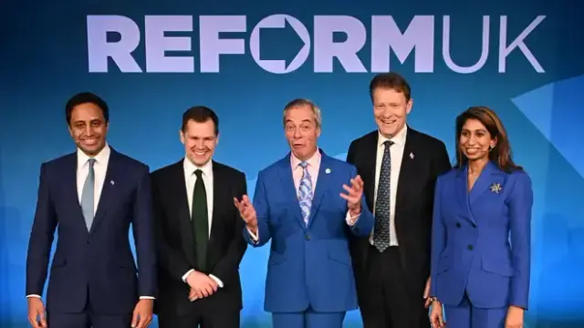 A picture of a bundle of guys, Who tell a bundle of lies...
...Zia Yusuf, Robert Jenrick, Nigel Farage, Richard Tice and Suella Braverman standing in front of Reform UK's logo.