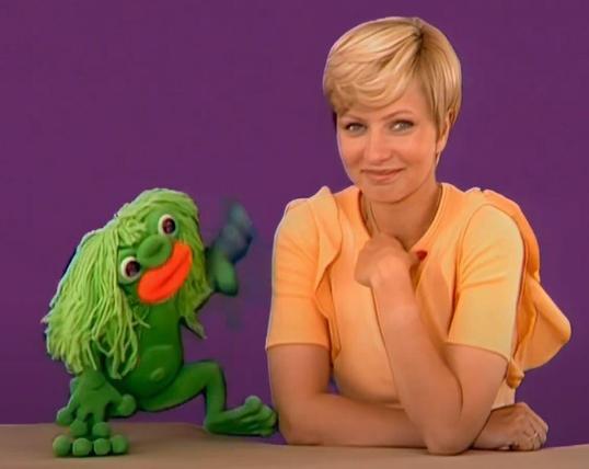 Eine froschähnliche Stoffpuppe, soll einen Wasserman darstellen, mit Namen "Plumpaquatsch"
Daneben die Moderatorin Susanne Beck