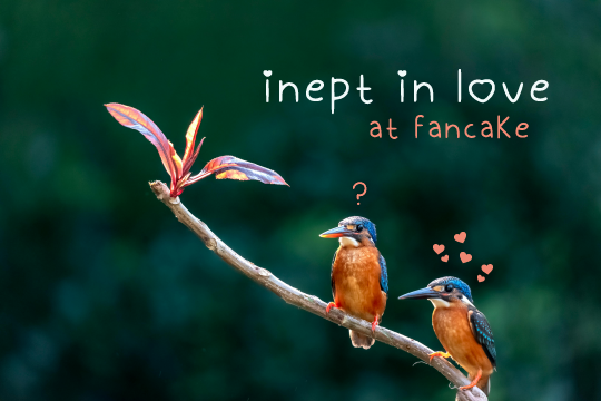 Photograph of two kingfishers perched on a branch. One is surrounded by a cloud of pink love hearts and the other has a single question mark over its head. Text: Inept in Love, at Fancake.
