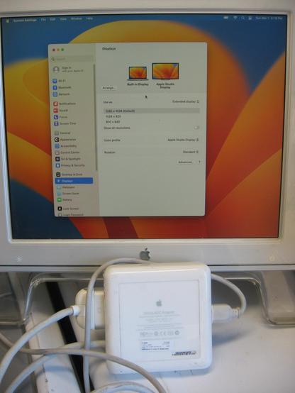 An Apple DVI to ADC adapter with a retro Apple cinema display having the latest OS X display settings window in view