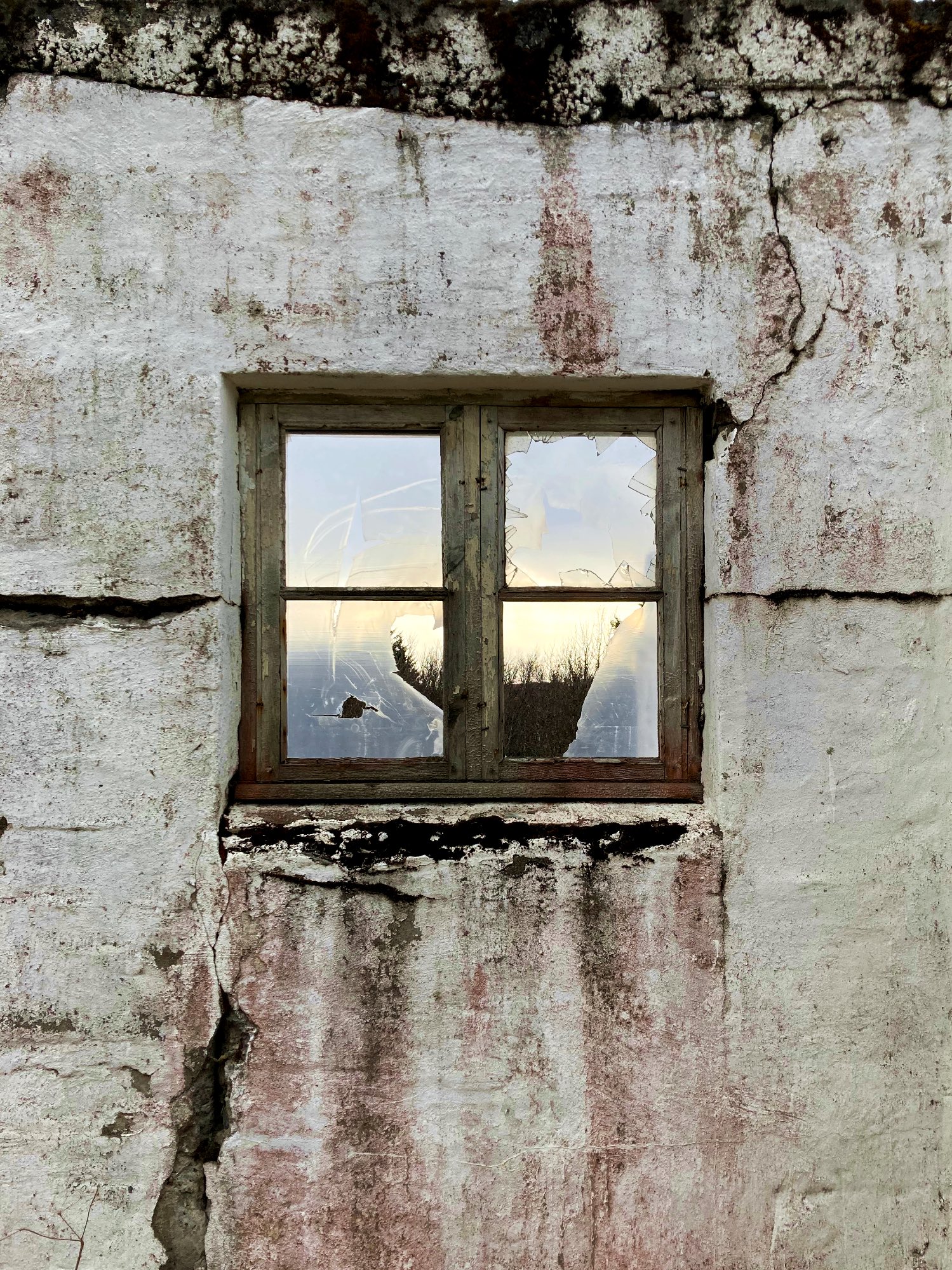 A small window covered in torn plastic.
