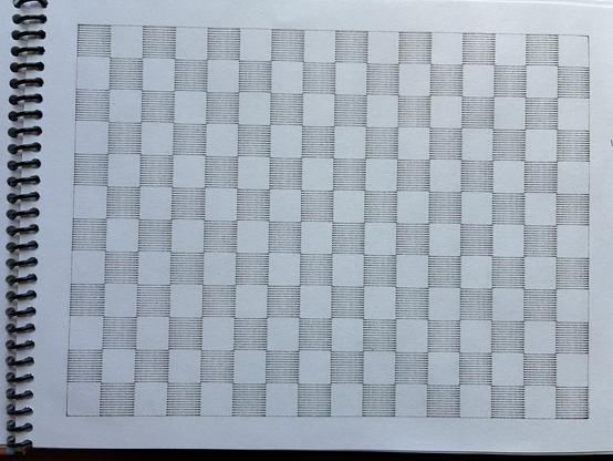 A page of a sketchbook with a checkerboard pattern drawn in it