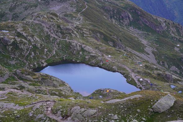 A lake near Lac Blanc with a number of tents around it.
