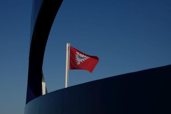 the flag of kiel seen through the front part of a ship, blue sky above