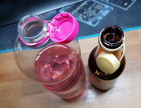 European attached plastic bottle caps; comparing 2 types.
On the left/pink, the sophisticated solution, with an engineered satisfying snap-action.
On the right/gold, the "cheap"-est, most cumbersome/annoying solution - "well, it's attached, we're compliant, shut up". EDIT: this IS a biased example! I've already twisted, and bent, it into shape, to comply with MY PERSONAL requirements! It's been, and it'll always remain, a nuisance - this flavour of "attached bottle cap".