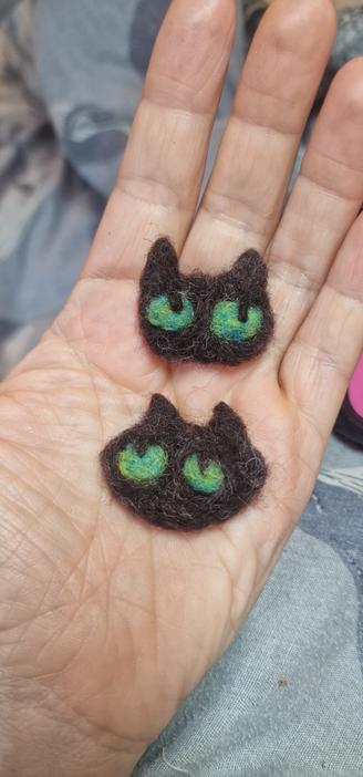 Two simple cat faces made of wool