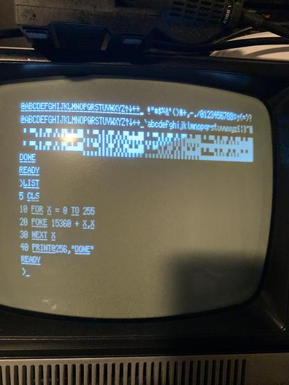 Output from the new Model 1 that shows a completely different character set that has all of the text characters with an underscore modifier. White text on a black and white TRS-80 monitor.
