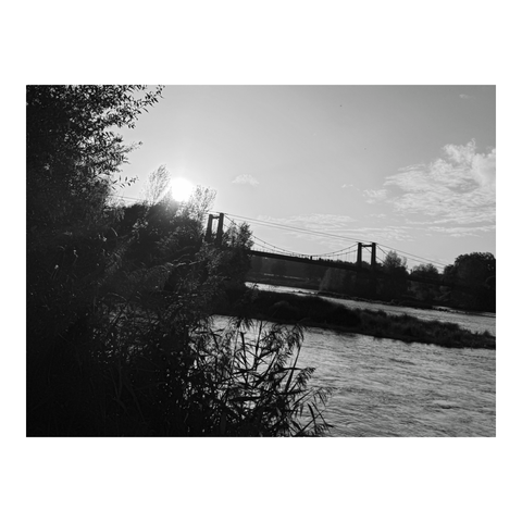 Suspended bridge over the river in the golden light of the setting sun. (Version françæ) Pont suspendux al-dessus dal rivière dans læ lumière doræ dal soleil couchanx.