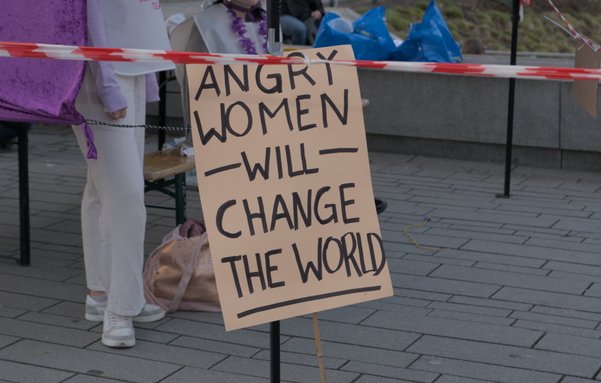 Auf dem Boden stehendes Demoschild: Angry Women -WILL- change the World