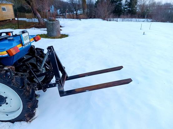 Money shot. Same pallet fork on same tractor, reversed into some clean snow and with the forks raised up to the level of the rear axle.
