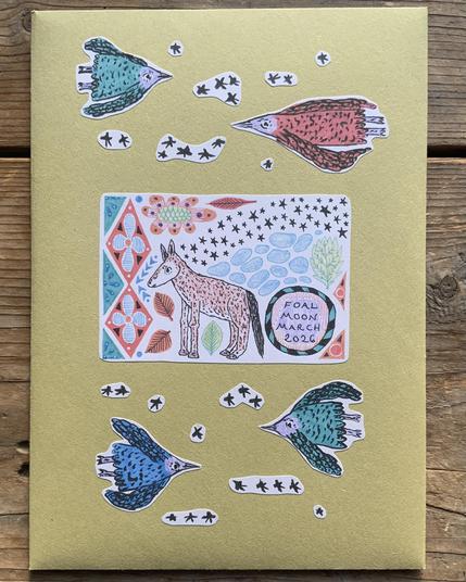 A handmade envelope with stickers on it of a foal, stars, flying birds, and patterns.
