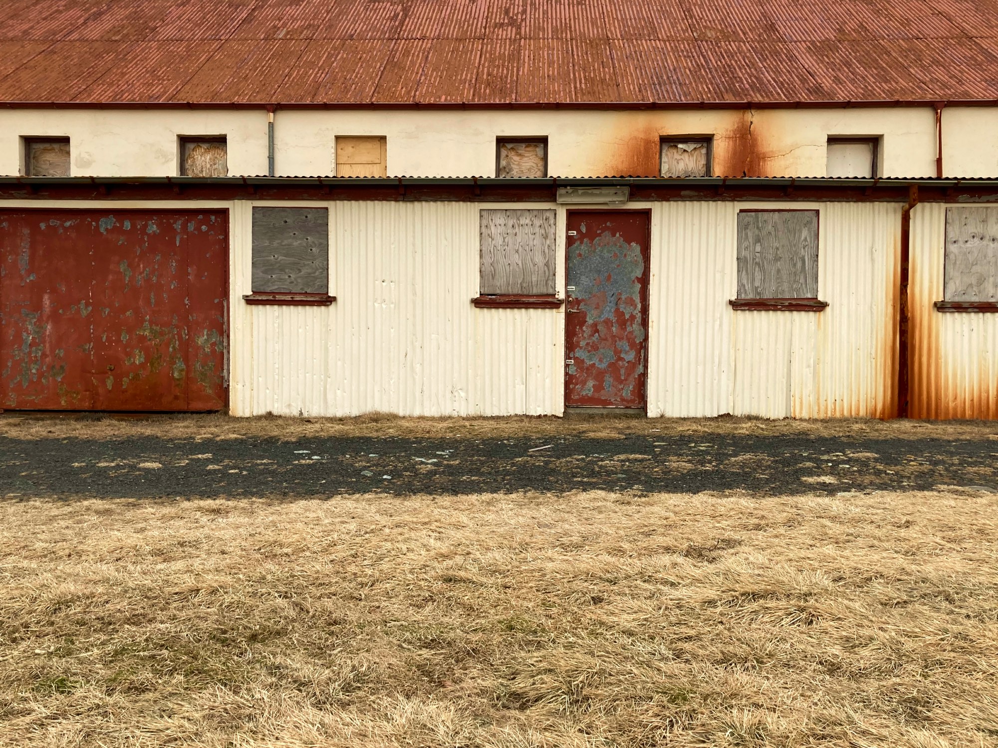 A run-down old barn with boarded-up windows and a rusty roof.