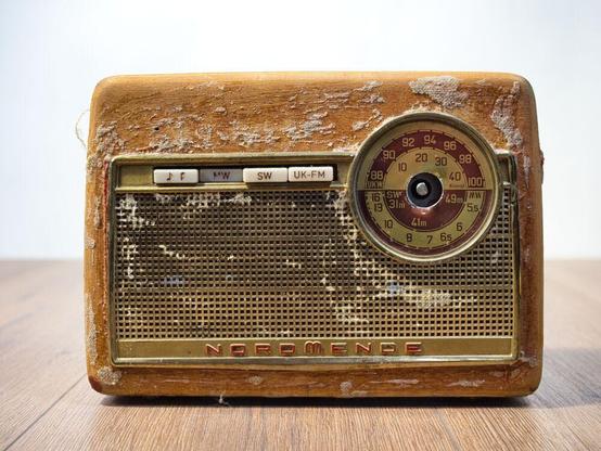 1960er Jahre Nordmende Kofferradio in abgerockten Zustand von vorne,
Der Knauf für die Sendersuche fehlt. Vom Stoff sind nur noch Reste vorhanden.