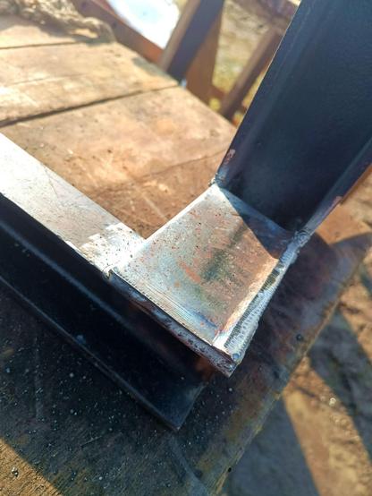 Bottom corner where the forks meet the frame. A 6mm plate cut from an angle iron is welded between forks and crossbar to strenghten the corner joint and handle twisting loads. The palletforks lay on their side on a workbench.