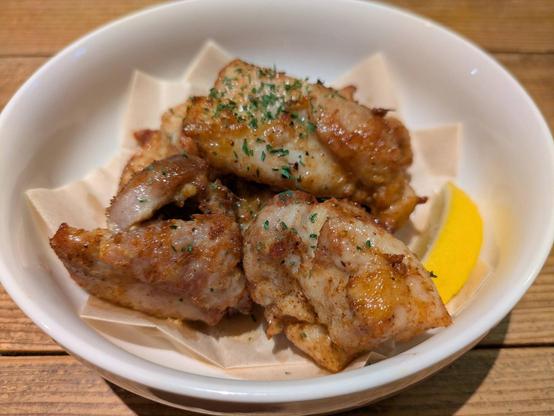 A large bowl full of Hawaiian style Michiko chicken with a lemon wedge