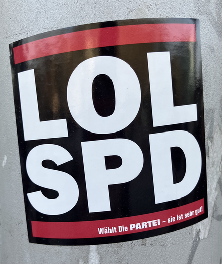 Ein Aufkleber von „Die Partei“ an einem Laternenpfahl mit der Aufschrift „LOL SPD“