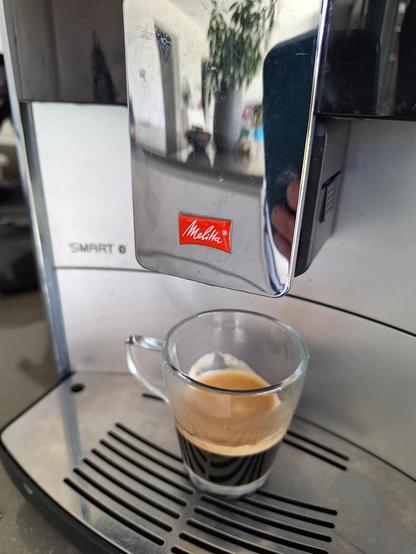 Freshly made espresso in glas under melitta coffee machine