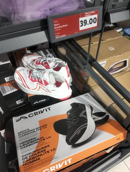 Out in a Lidl store in Malta, the much talked about Lidl own brand Crivit carbon plate super shoe, which costs...โฌ39.00
The shoe box shows a black and grey shoe with thick white cushion and black rubber sole. On the top is a white and red version