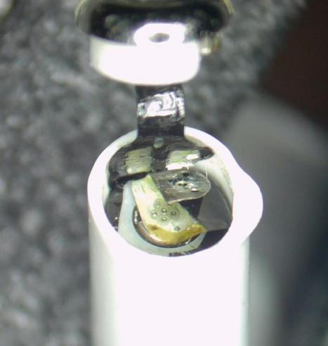 Look inside an airpod. The top cap has been removed, the battery and some contacts can be seen.