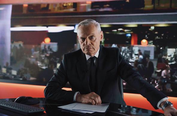 <p><em>This article first appeared in </em><strong><em>Radio Times magazine</em></strong><em>.</em></p><p>At Westminster Magistrates Court on 31 July 2024, Huw Edwards pleaded guilty to making indecent images of children. So ended, in public disgrace, the career of a BBC newsreader who only two years before had told the nation that Queen Elizabeth II was dead.</p><p>Falls from grace are seldom so spectacular and now, invariably, there is a television drama to recount it. Power: the Downfall of Huw Edwards stars Martin Clunes as Edwards and he gives a remarkable performance that is revealing in every detail. The short back and sides with exact side-parting, the arm extended over the desk to project authority, the portentous Welsh tone: Clunes nails it all.</p><p>“Edwards delivering the news of the Queen’s death is so well known, that it needed mimicry from me, in a way,” says Clunes. “Those rhythms and sounds had to be spot on. I was happy to get it sounding right.”</p><p>Apparently happily married with five adult children, when not reading the news Edwards was paying a series of young men for sexually explicit images. The script is based on text messages between Edwards and a 17-year-old in south Wales, Ryan (not his real name), played with aching vulnerability by Osian Morgan. After sending texts demanding pictures, Edwards would calmly address the nation.</p>
<img alt="Martin Clunes in Power: The Downfall of Huw Edwards, sitting in a dark room with brown walls and a plain s