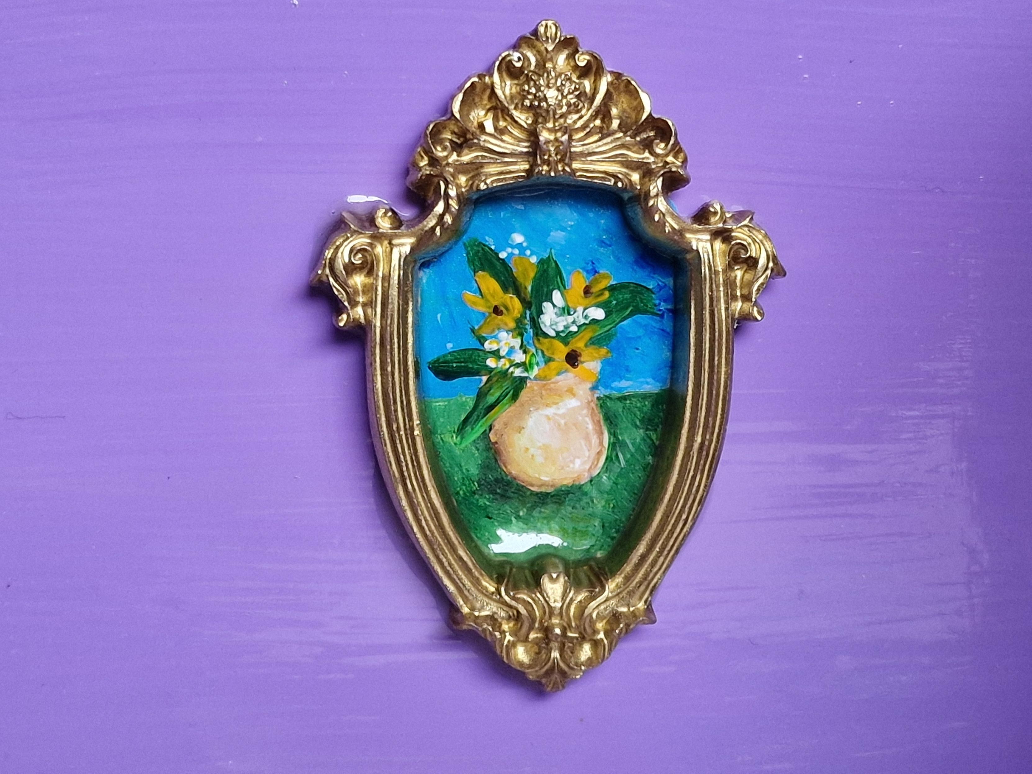 Tiny painting of a vase of flowers in a gold frame