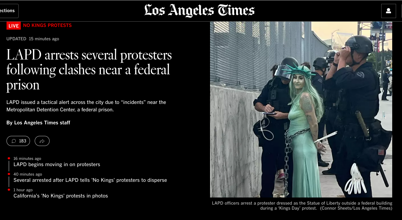 LA Times coverage of protests, shows a woman dressed up like the Statue of Liberty tied with zip ties and an officer writing something down