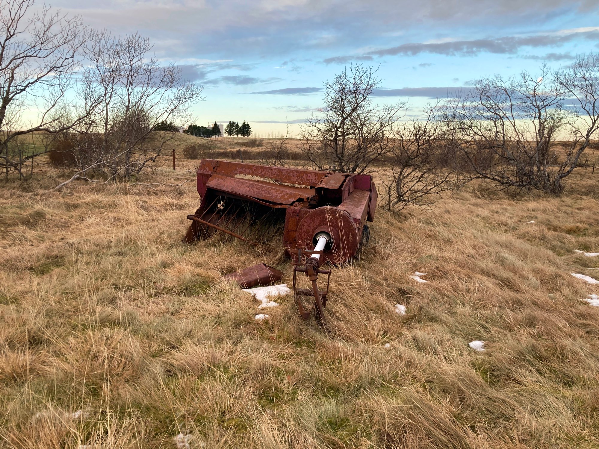 Rusty farm equipment and a sunset.