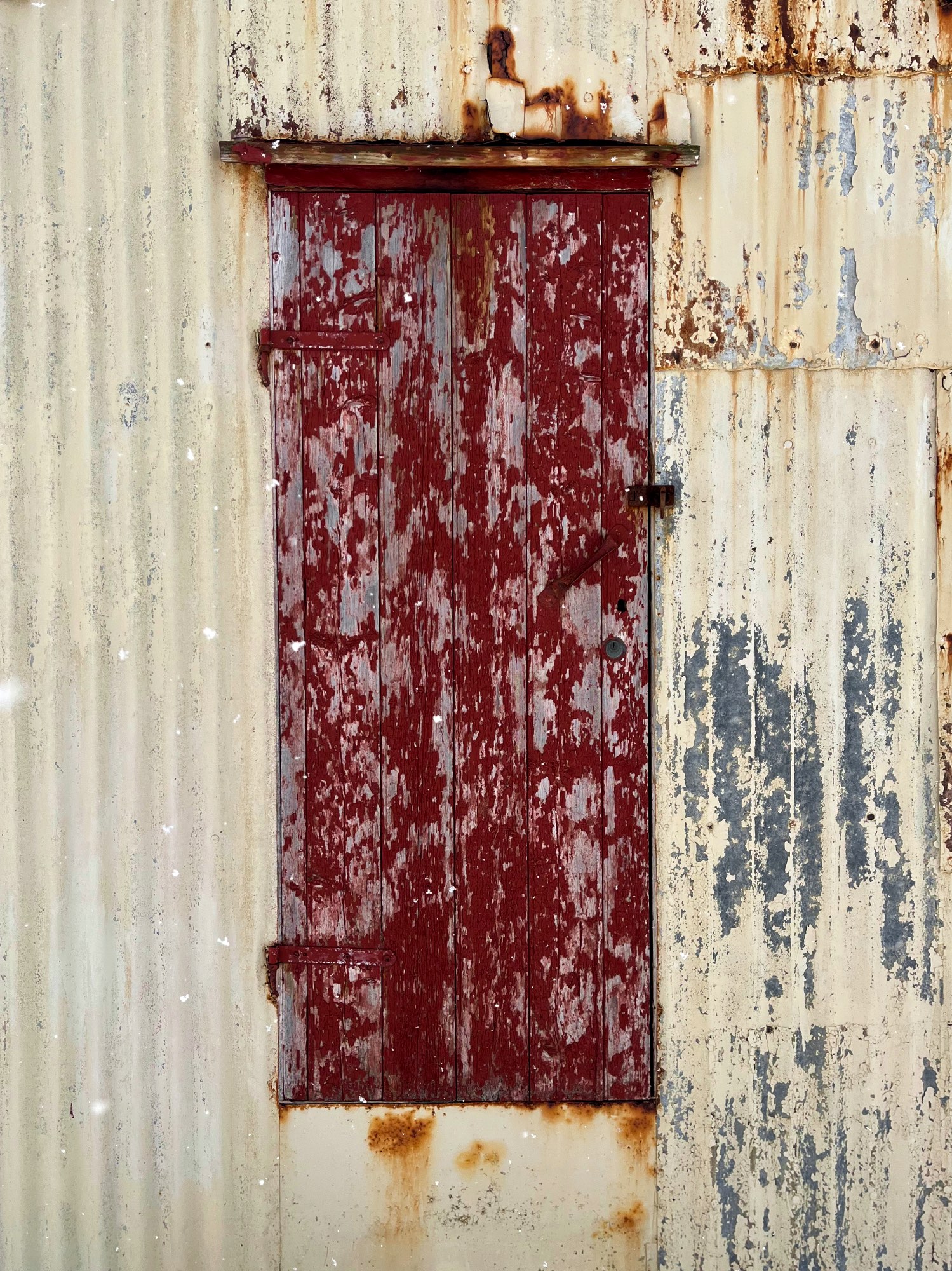 A small red door to an abandoned barn.