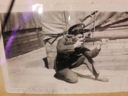 my father at his Basic Training graduation in April of 1942. he is in his Class A uniform, and has taken a kneeling position with his bolt-action M1903 Springfield rifle. he looks silly, as only a new Boot Camp grad can.
