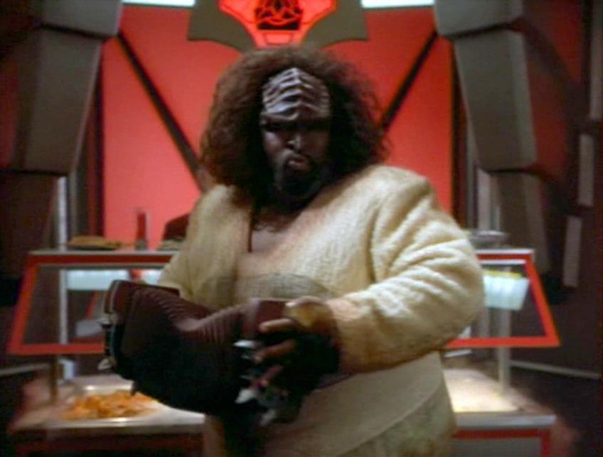 It's the person who runs the Klingon restaurant on Deep Space Nine, a heavyset Klingon man who in this image is playing some kind of Klingon concertina. I am completely serious when I say he is the best character in all of Star Trek, and I will fight to the death for his right to sell us racht and sing to us while we eat.
