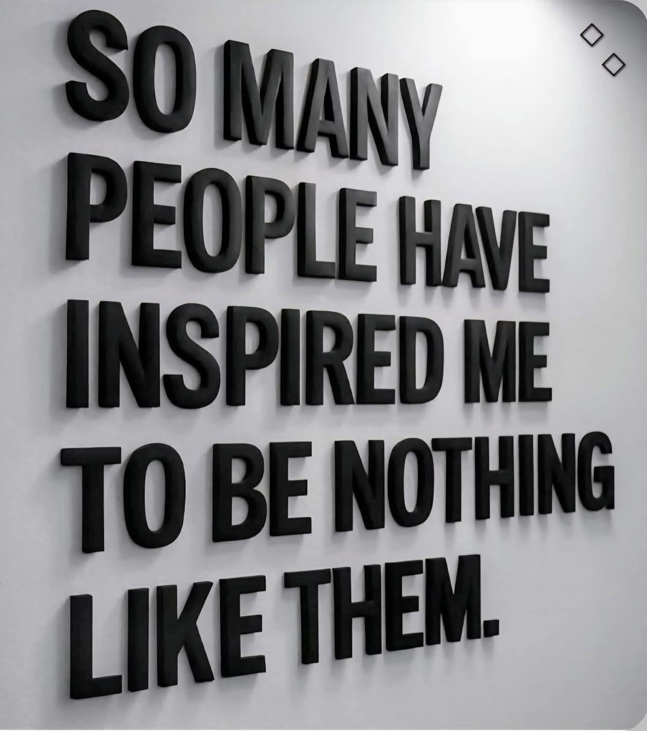 A sign with black lettering against a white wall. It reads "So many people have inspired me to be nothing like them."