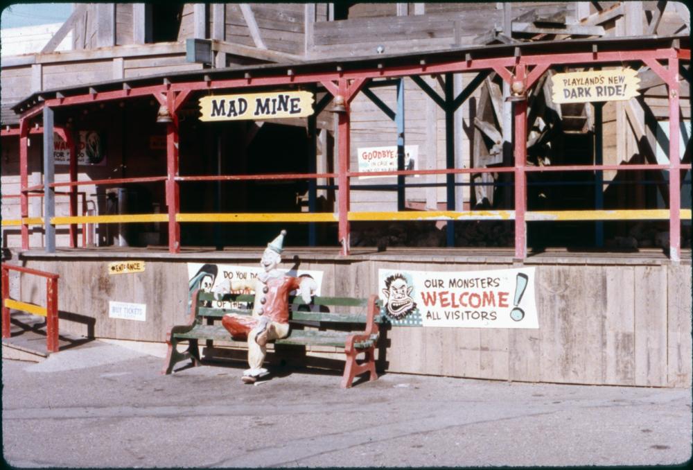 Playland 1972 The Mad Mine ride with a seated clown figure on a bench, the clown looks pretty faded and worn out.