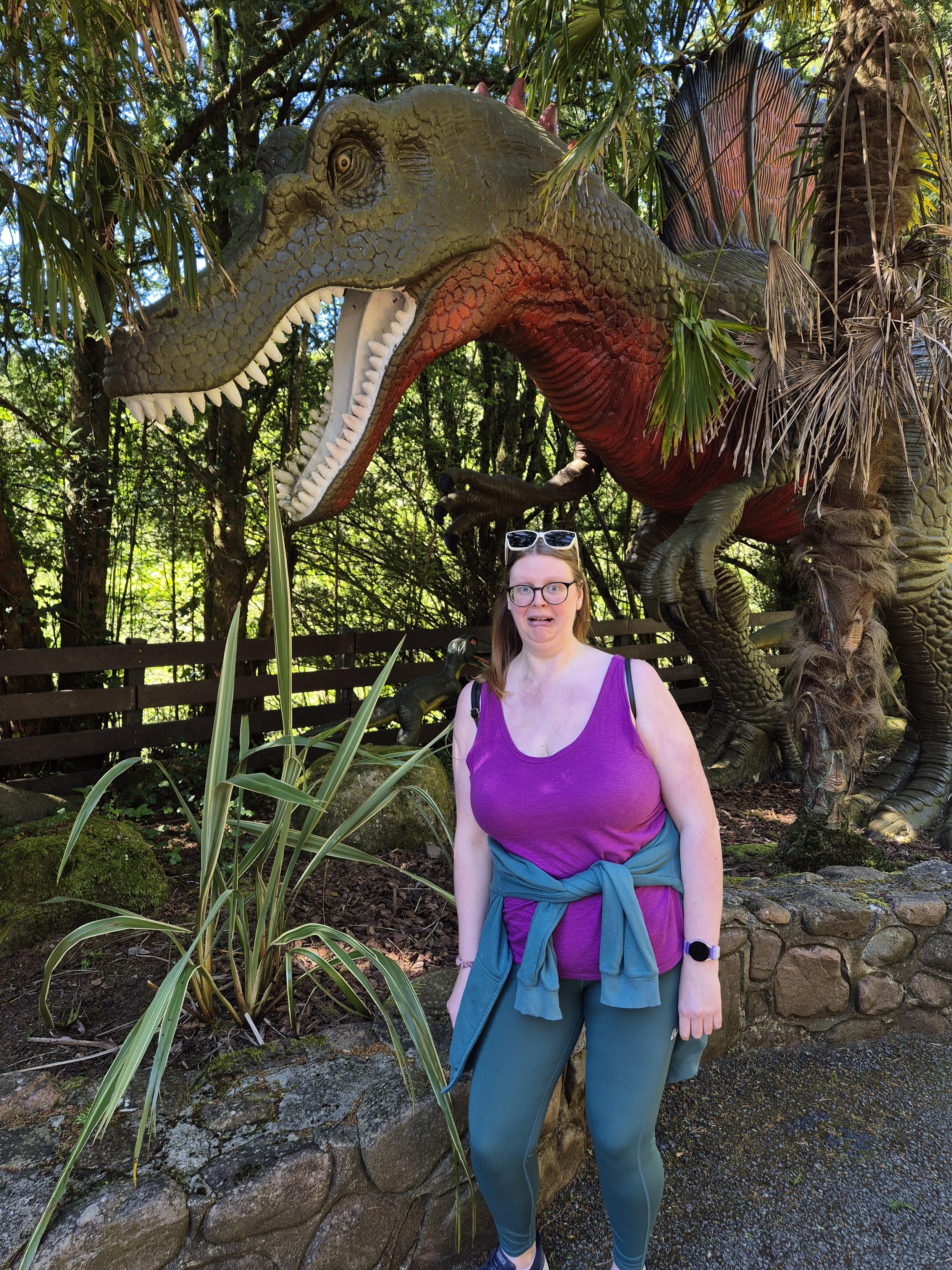 Rosie, looking concerned in front of an animatronic dinosaur