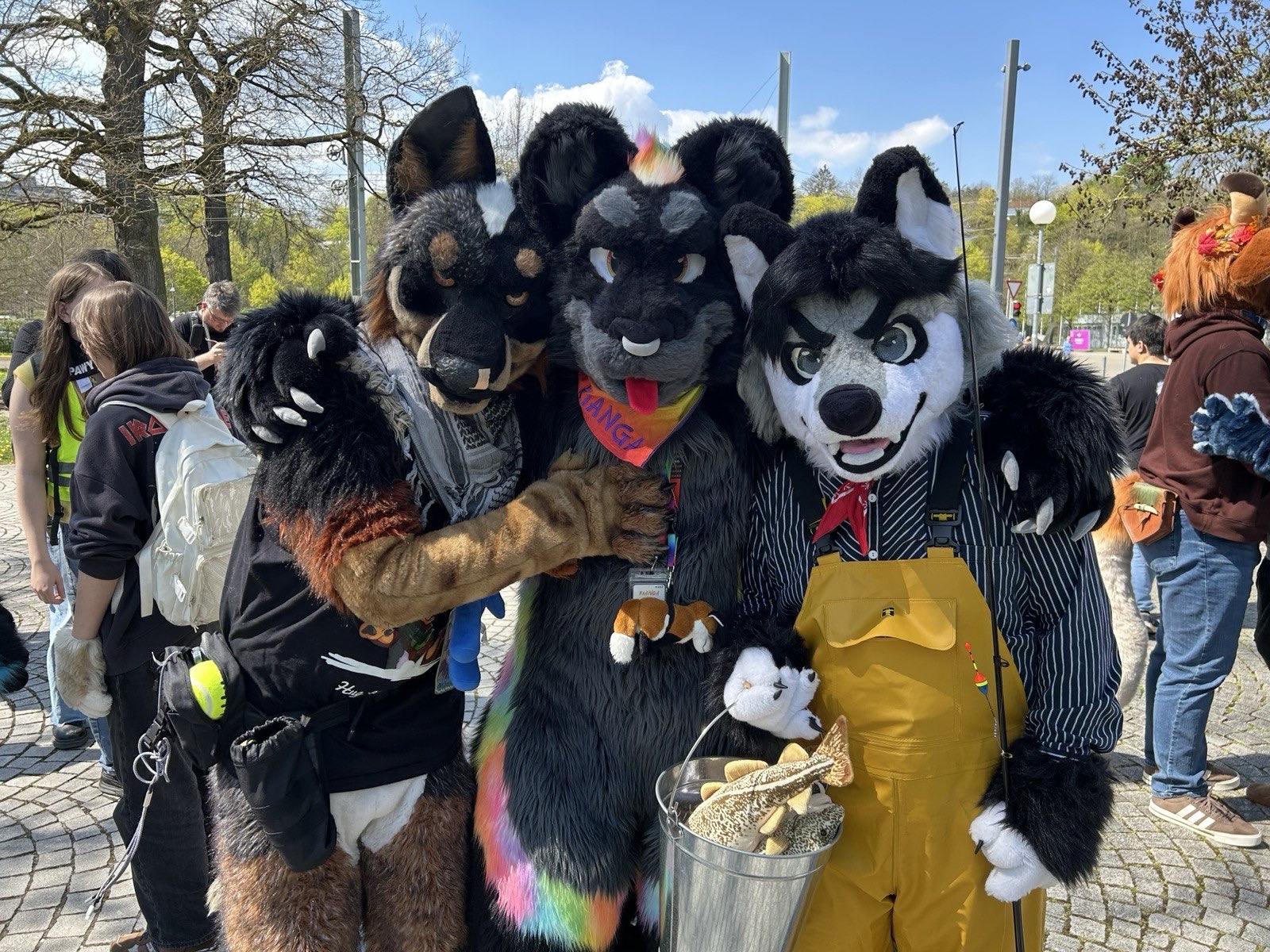 Wusky, jaguar and Blue Heeler fursuiters hugging each other.