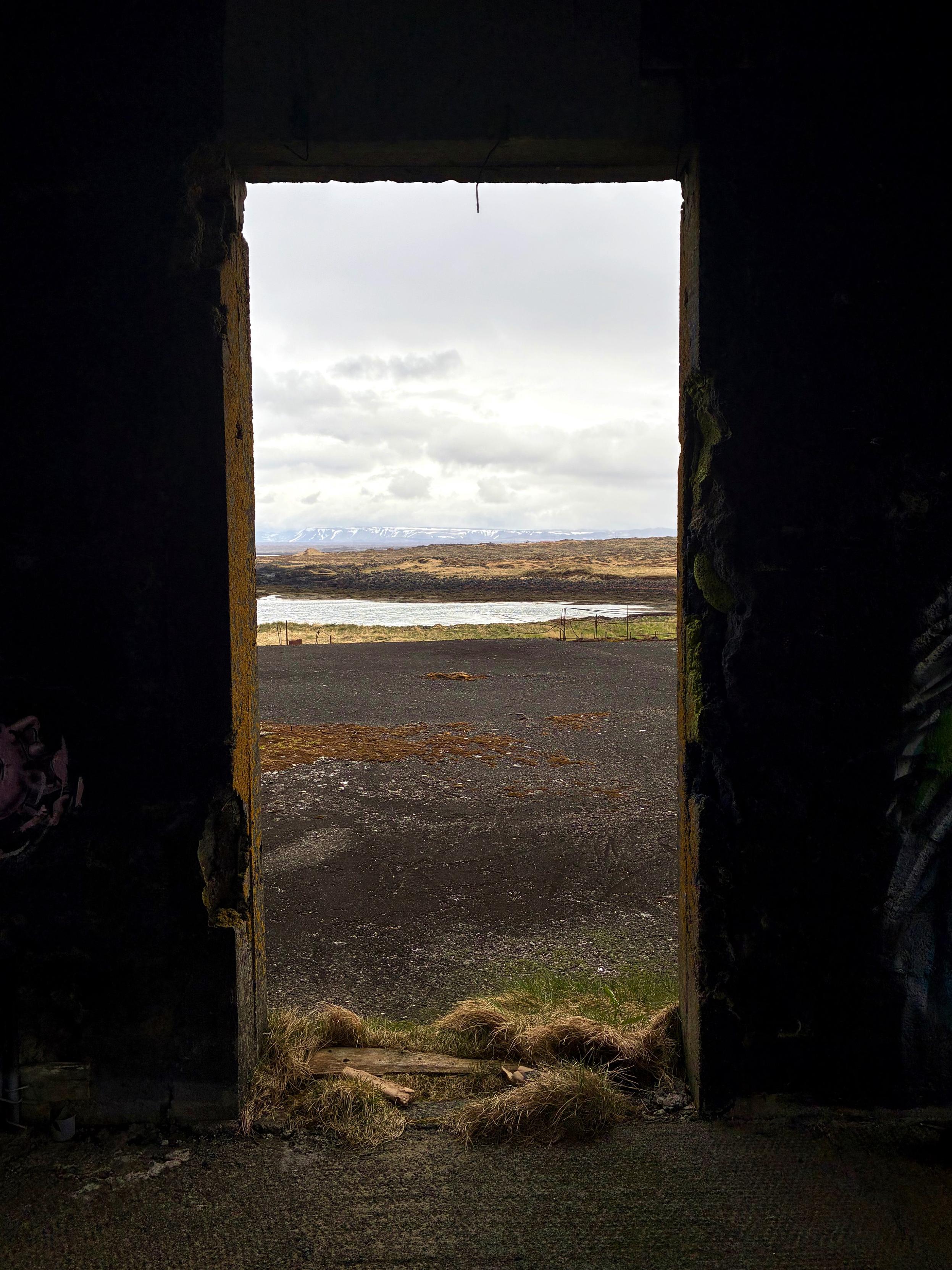 A doorway in an abandoned building overlooking the sea.