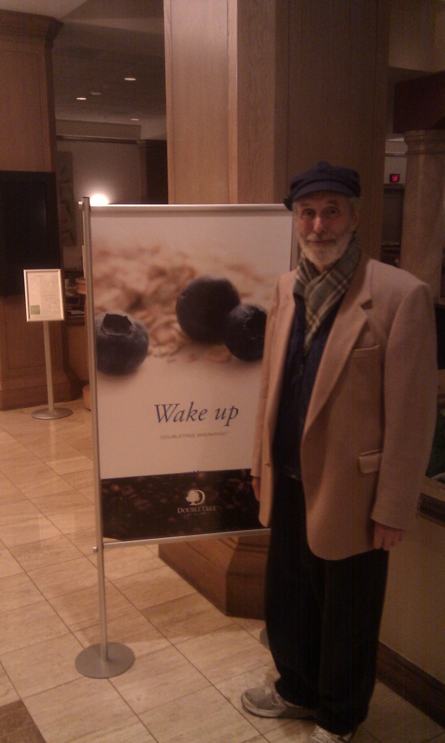 Peter, standing next to a sign that says 'Wake up'.