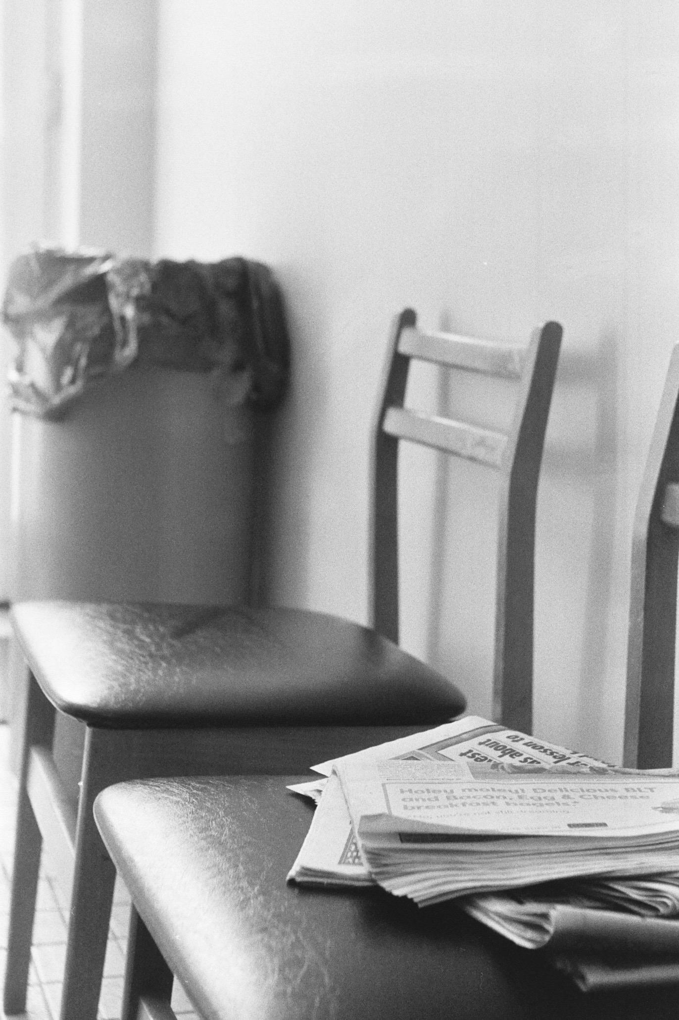 Newspapers piled on chairs in a Clifton laundromat.