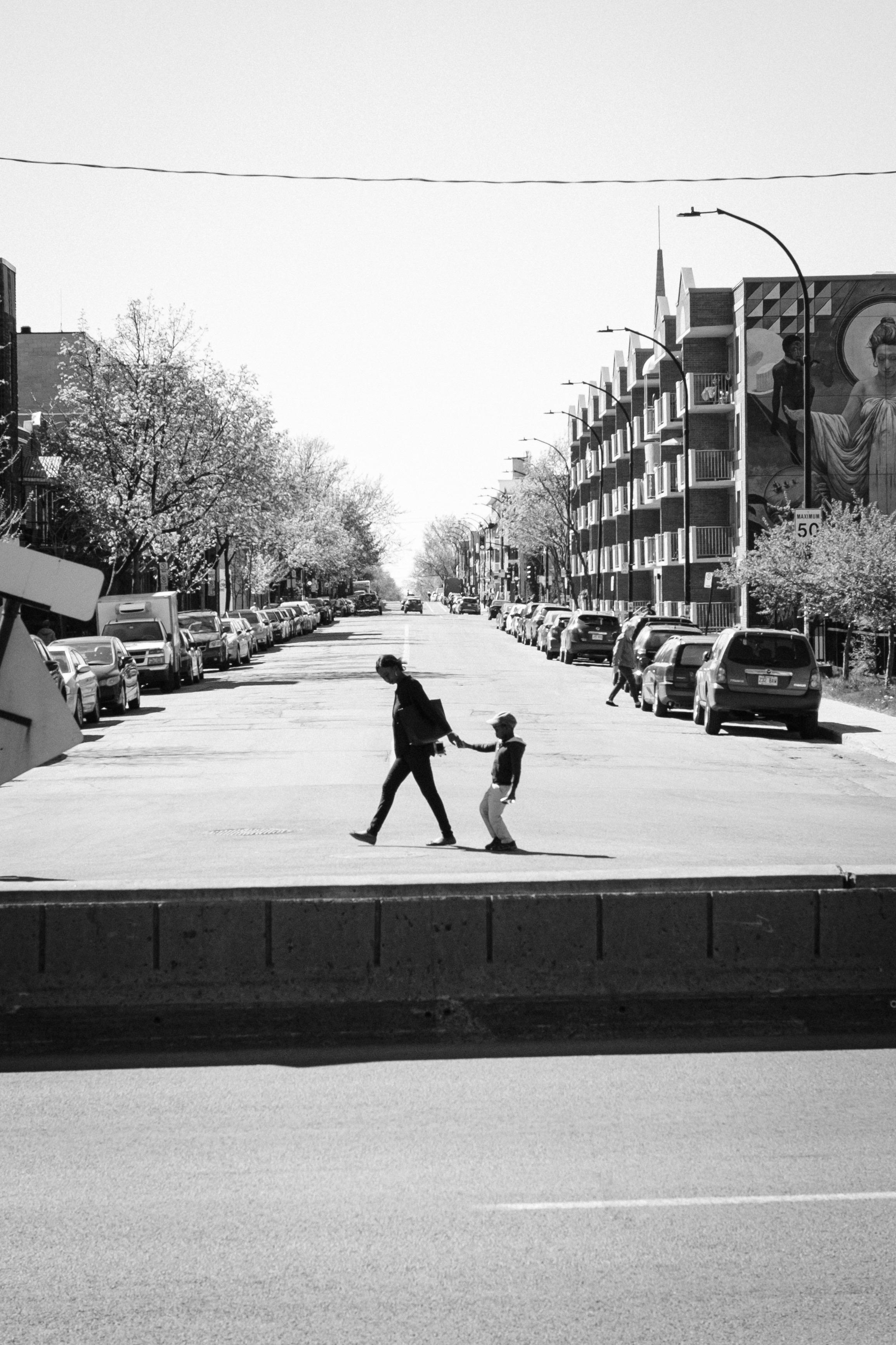 A mother dragging a reluctant child over the road in Montréal.