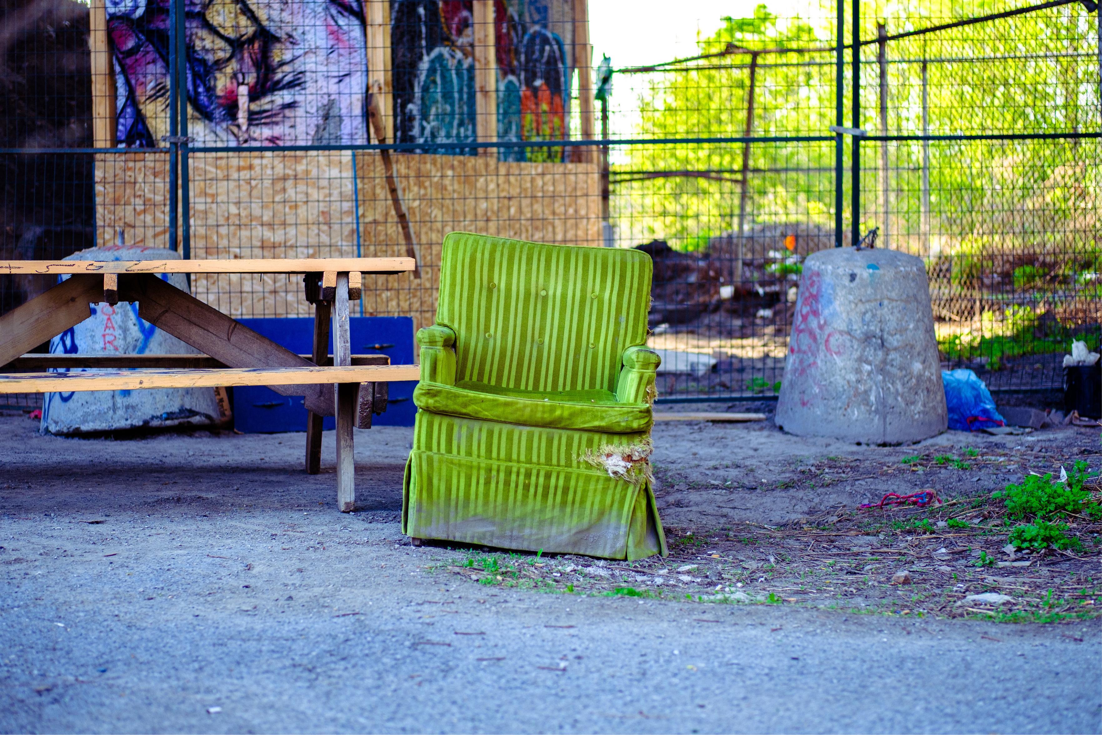 A very green armchair that was left under a bridge in Montréal.