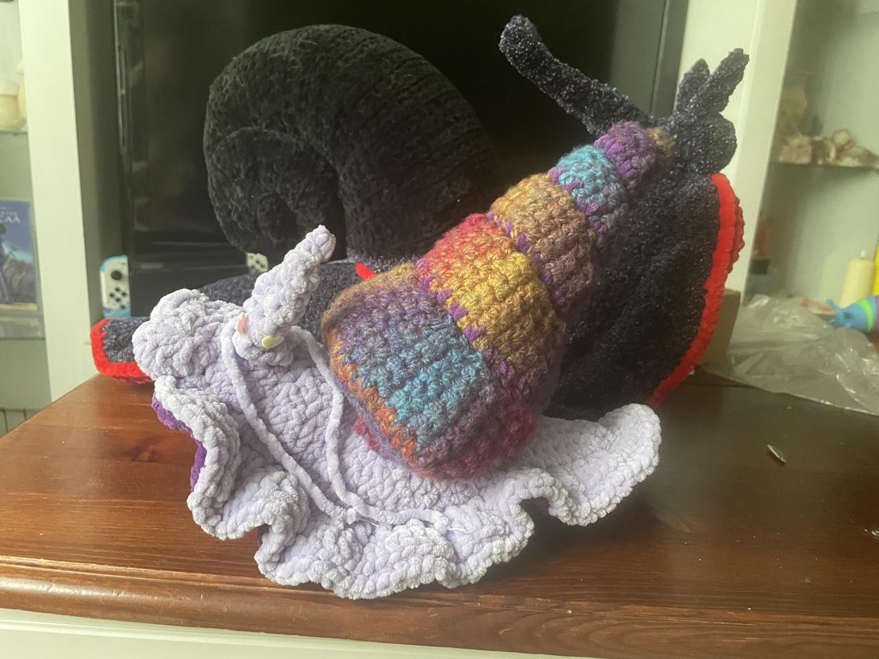 small lilac snail with a multicoloured pointy spiral shell.