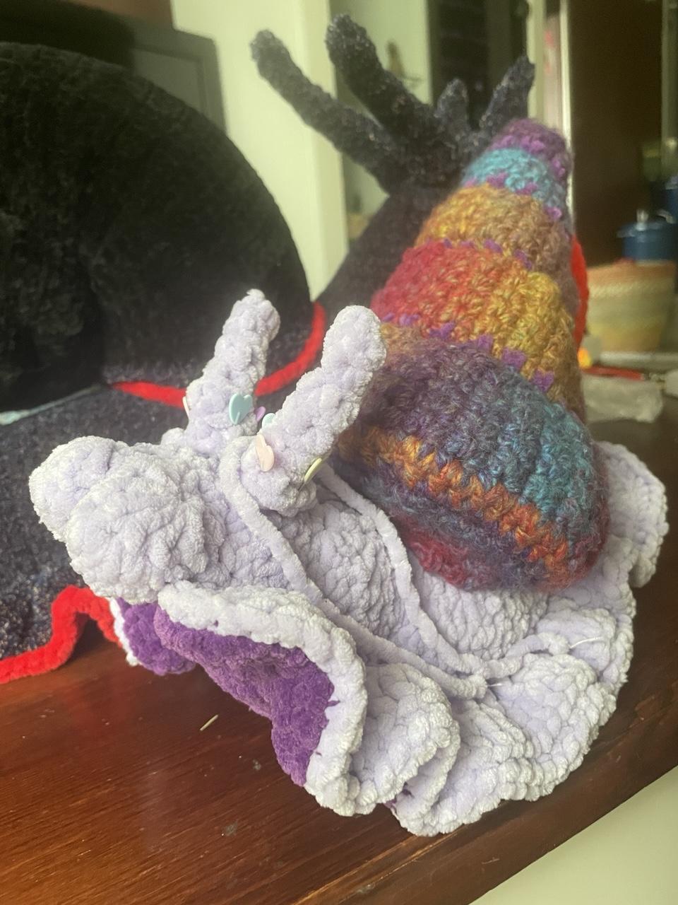 same snail from front. its underside is crocheted from a darker violet yarn.