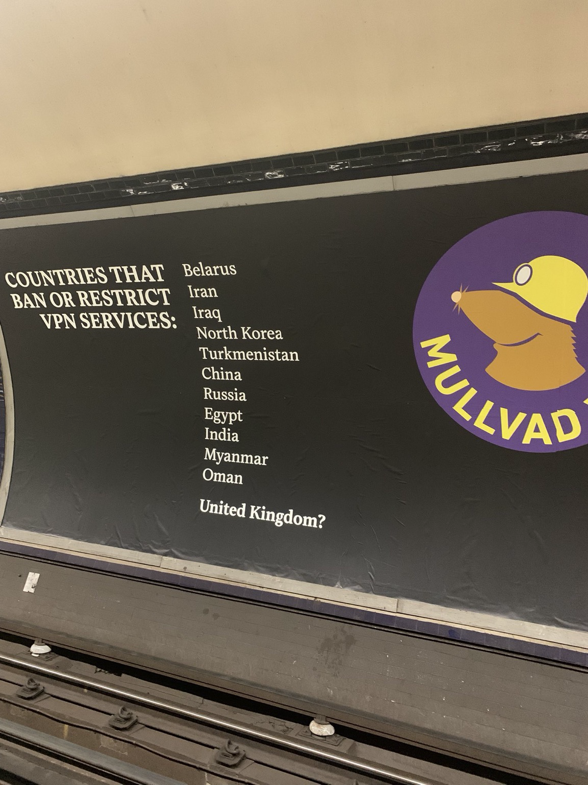 @JamesBaker @mullvadnet (Large printed add displayed on the far side of subway tracks:  countries that ban or restrict VPN services: Belarus Iran Iraq North Korea Turkmenistan China Russia Egypt India Myanmar Oman United Kingdom (with a ? after it).  Mullvad logo of a simply drawn cartoon mole with a miners hardhat with a light down over its eyes. The mole is apparently smiling.