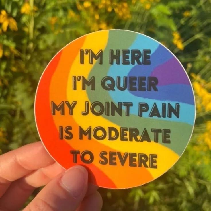 Sticker with a wavy rainbow, and the words, “I’m here, I’m queer, my joint pain is moderate to severe”