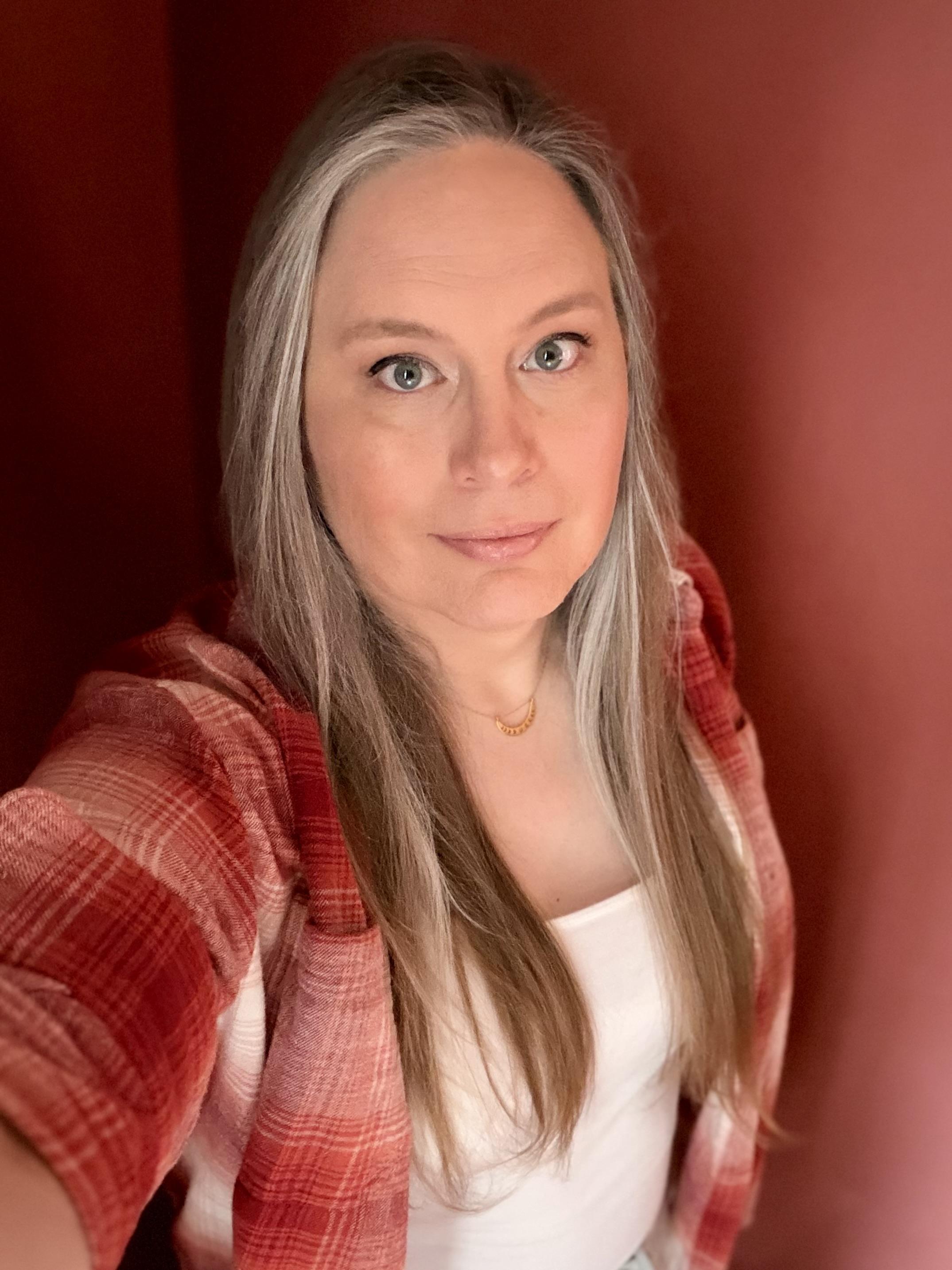 Selfie of a lesbian trans woman wearing a flannel shirt and a pretty face.