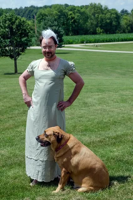Me in my yard, in a regency dress, with a dog and a fascinator. This is from 2013.