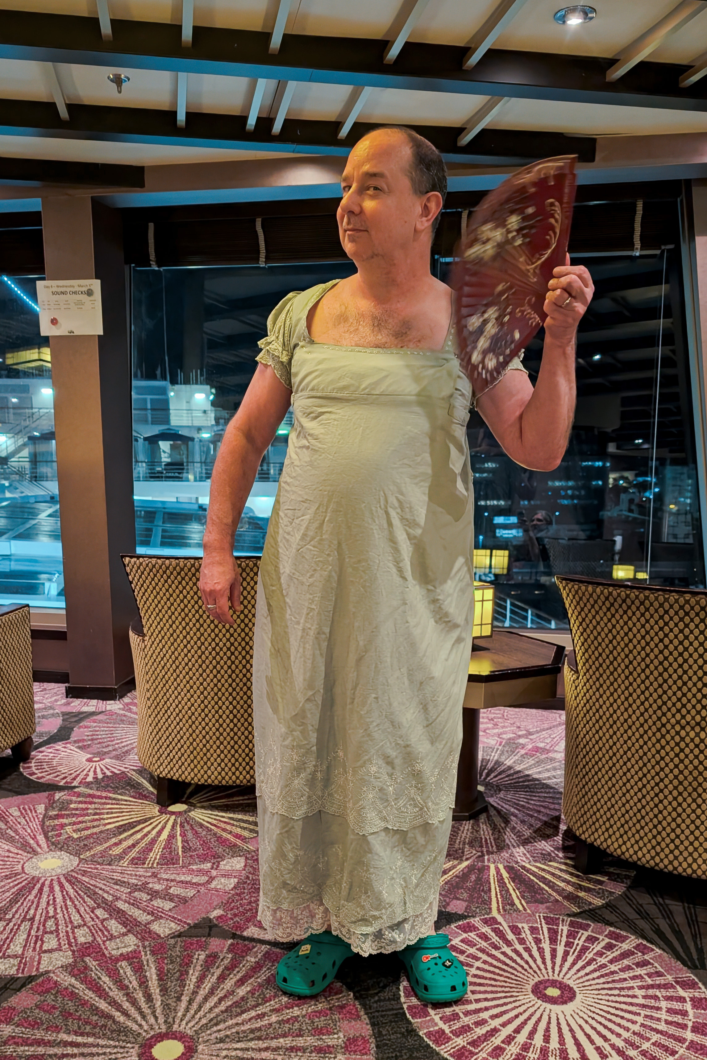 Me in a regency dress, with fan and Crocs. This is from 2025.