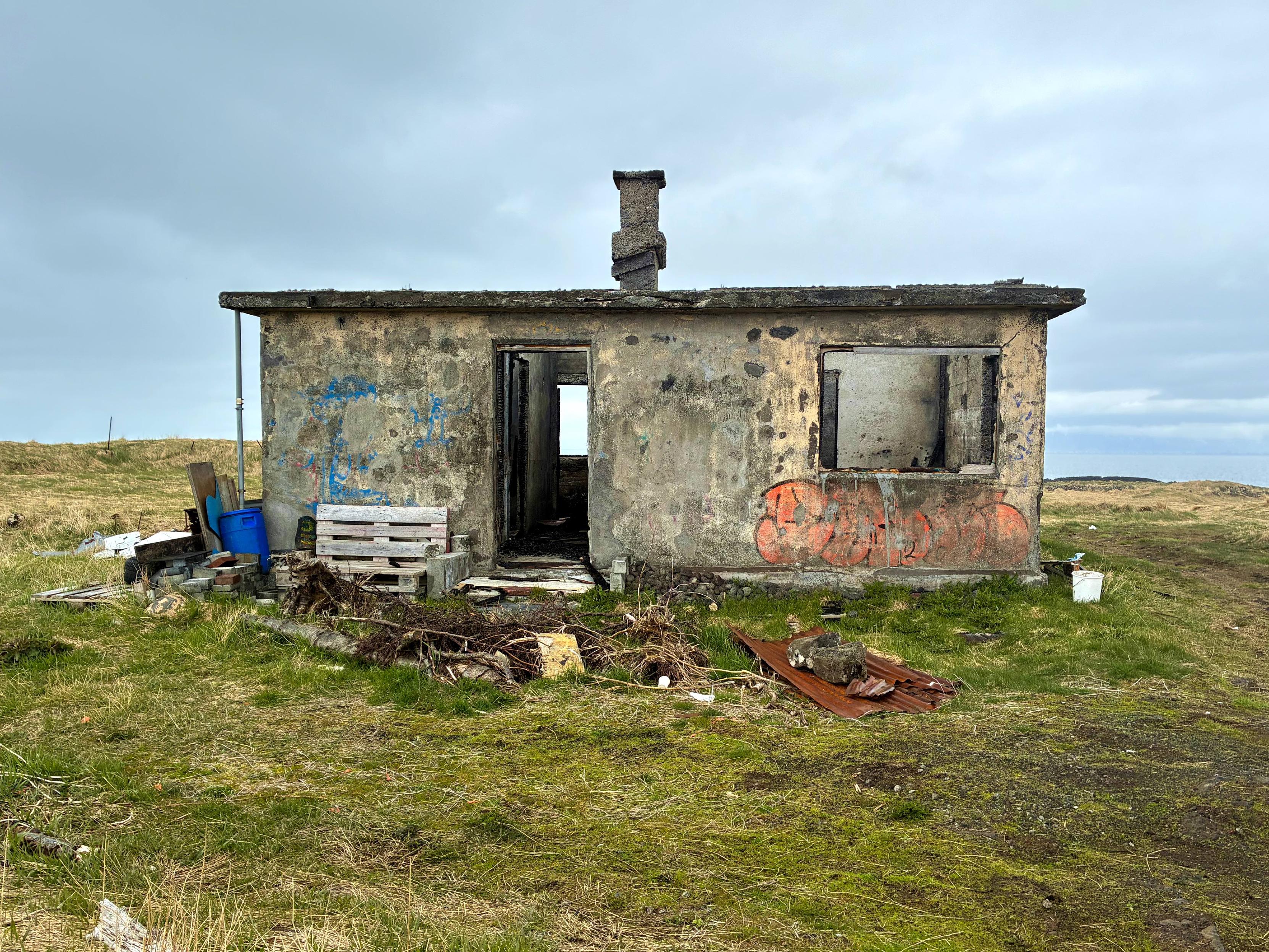 The remnants of a small abandoned concrete house.